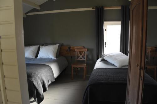 博克斯特尔Buitenuit的一间卧室设有两张床和窗户。