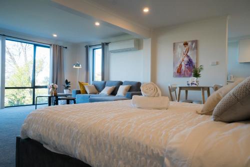 霍巴特Amazing Sea Views Luxury Guest House的一间大卧室,配有一张大床和一张沙发