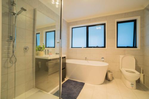 霍巴特Amazing Sea Views Luxury Guest House的带浴缸、淋浴和卫生间的浴室