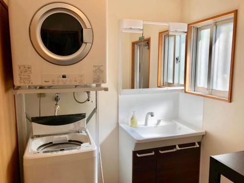 读谷村人生旅程旅馆的一间带水槽和洗衣机的小浴室