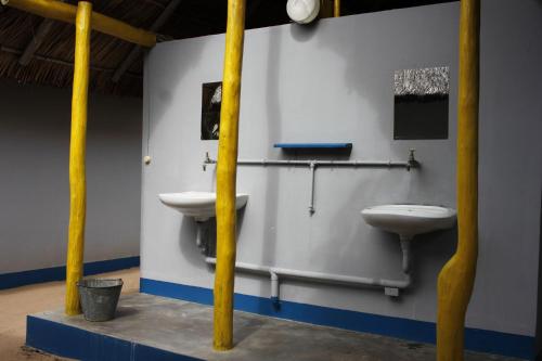 维兰库卢什Complexo Alemanha - Vilanculos Backpacker的一间带两个卫生间和盥洗盆的浴室