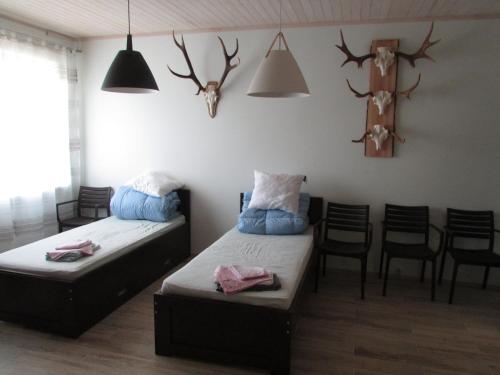 KihelkonnaKihelkonna Jahimaja majutus的一间设有两张床和一张桌子及椅子的房间