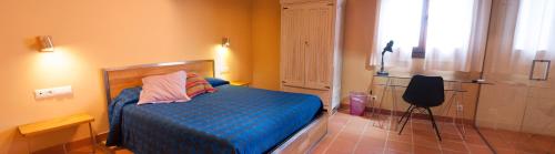 托尔托萨托雷德尔普莱尔酒店的一间卧室配有一张床和一把椅子