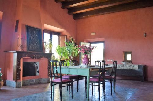 珀古萨Agriturismo Baglio Pollicarini的一间带桌椅和壁炉的用餐室