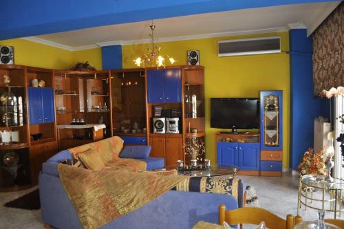 塞萨洛尼基Spacious Apartment的客厅配有蓝色的沙发和电视