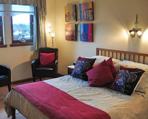 East CalderAshcroft Farmhouse的一间卧室配有一张床、两把椅子和一个窗户