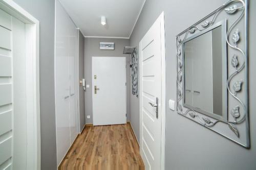 比得哥什Apartament Gdańska的走廊上墙上有镜子,门上有一个门