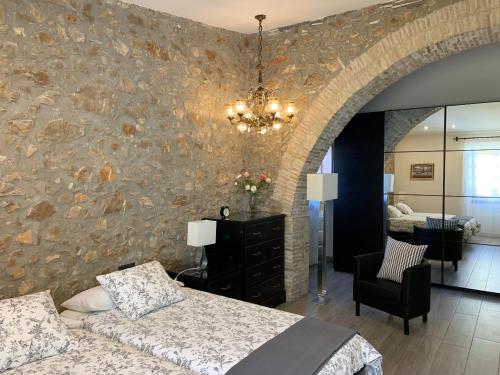 莱斯卡拉Casa de piedra adaptada en LEscala的一间卧室设有石墙、一张床和一把椅子