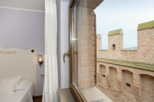 格拉达拉Dimora della Rovere的卧室设有砖墙窗户