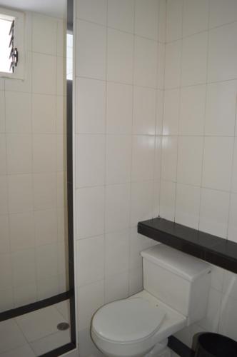 加拉加斯Hotel Tiburon的一间带卫生间的浴室和白色瓷砖墙