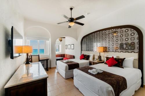 坎昆GR Caribe Deluxe All Inclusive的酒店客房设有两张床和一张桌子。