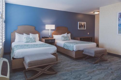 锡拉丘兹The Parkview Hotel的酒店客房设有两张床和蓝色的墙壁。