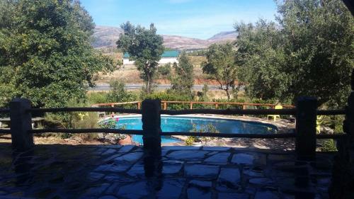 Perales del PuertoLa Simona Casa Rural的透过围栏可欣赏到游泳池的景色
