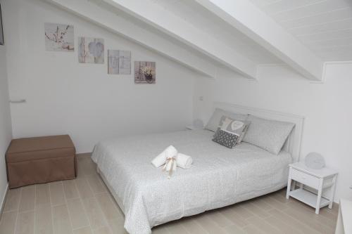 皮蒙泰Rosy House - Hospitality的一间白色的卧室,配有一张带弓的床铺
