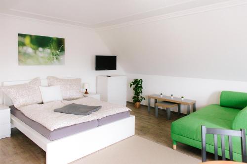 埃伦豪森Steira-Studios的一间卧室配有一张床和一张绿色沙发