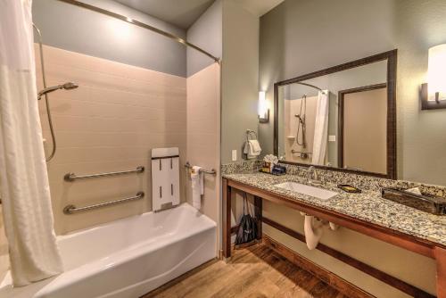 摩根堡奥弗兰贝斯特韦斯特优质酒店的带浴缸、水槽和镜子的浴室
