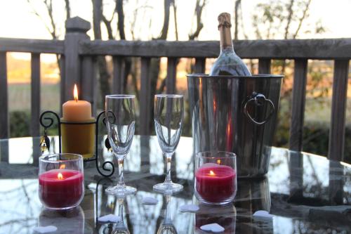 贝济耶爱的小屋酒店的一张桌子,上面放有酒杯、一瓶和蜡烛