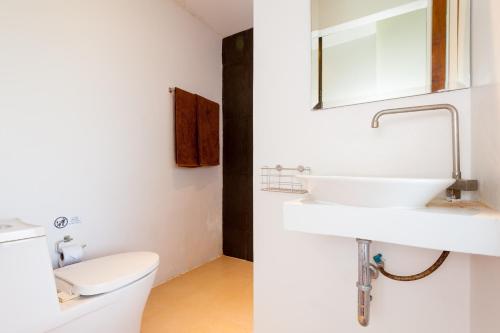 涛岛Coral View Resort的白色的浴室设有水槽和卫生间。