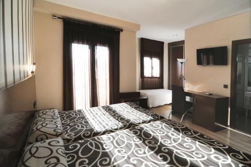 普拉森西亚普拉森西亚城市酒店的酒店客房设有一张大床和一台电视。