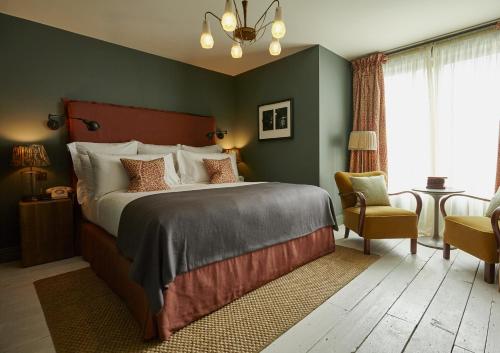 伦敦Redchurch Townhouse的一间卧室配有一张大床和一把椅子