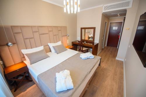 阿拉木图阿斯塔纳国际酒店的一间卧室配有一张大床和毛巾