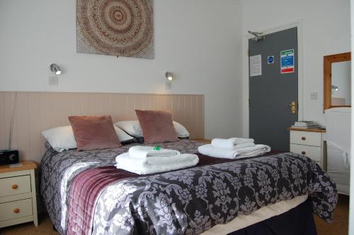 法尔茅斯特雷珍娜宾馆的一间卧室配有带毛巾的床
