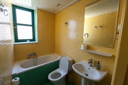 纳夫普利翁Tis Mammis的浴室配有盥洗盆、卫生间和浴缸。