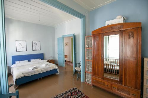 纳夫普利翁Tis Mammis的一间卧室配有一张床和一个木制橱柜