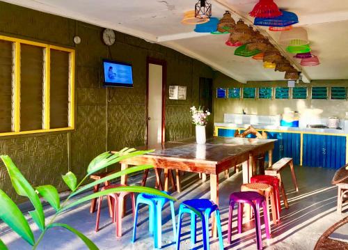 曼巴豪Lanzones Cabana的用餐室配有木桌和五颜六色的椅子