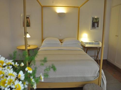 米尔芳提斯城米尔雷斯酒店的一间卧室配有床和两张桌子,鲜花盛开