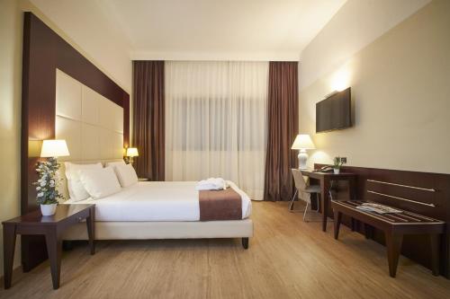 米兰iH Hotels Milano Watt 13的配有一张床和一张书桌的酒店客房