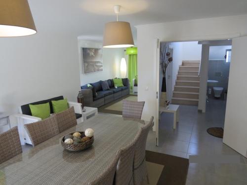 蒙蒂戈杜Villa de vacances 3 chambres et 6 couchages max. à proximité de mer à Praia Verde Algarve的客厅和带桌椅的用餐室