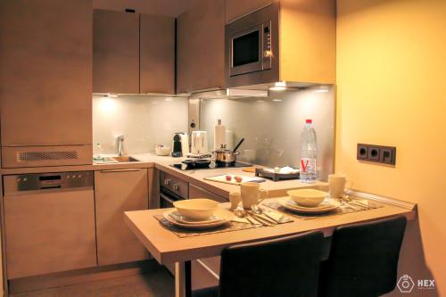 杜塞尔多夫蓝石公寓式酒店的厨房配有带餐具的桌子
