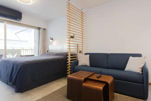 戛纳Cannes NEW Apartment, Palais Des Festivals, CROISETTE, Beaches的一间卧室配有一张床和一张蓝色的沙发