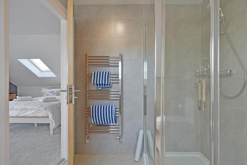 纽基Haven Lodge Newquay的带淋浴的浴室、2把椅子和1张床