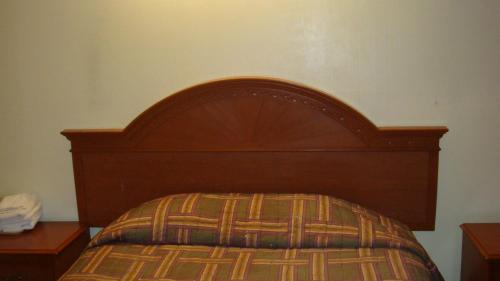 爱迪生美思特汽车连锁旅店的一张带木制床头板的床