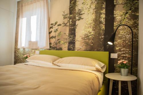 萨尔扎纳Gardenhouse Sarzana的卧室内一张带绿色床头板的床