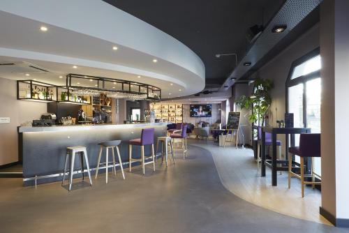 勒布朗-梅尼尔布朗梅尼尔钟楼酒店的餐厅内的酒吧,带紫色凳子