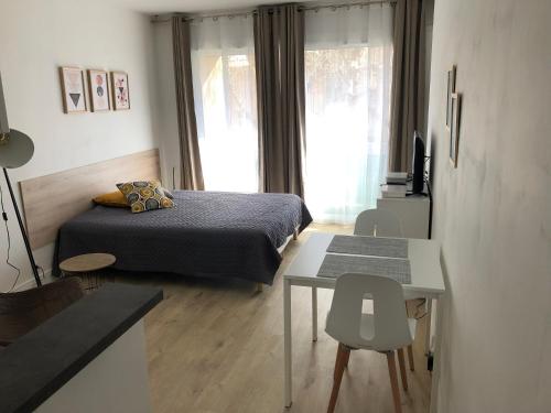普罗旺斯艾克斯Aix Homes的一间卧室配有一张床、一张桌子和一个窗户。
