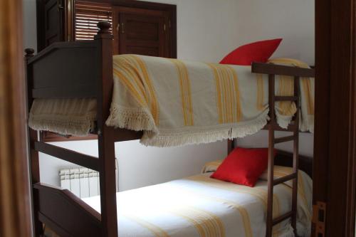 卡皮雷拉Apartamentos Rurales Rosendo: El Azahar的一间卧室配有两张双层床和红色枕头