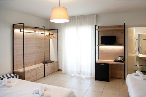 里乔内Hotel Majorca sul Mare in centro a Riccione的带一张床和窗户的卧室