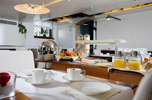 威尼斯帕拉佐吉欧瓦奈利格兰运河酒店的厨房配有带盘子和橙汁杯的桌子