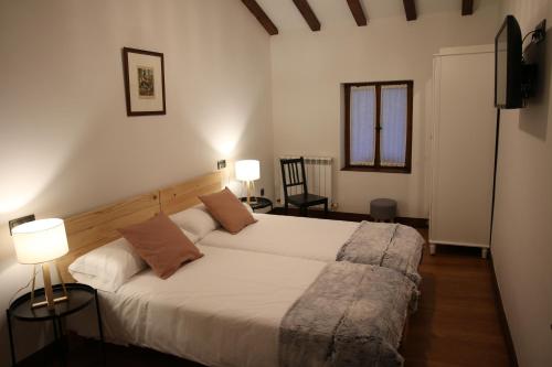 莱特萨Casa Rural Iruso的一间卧室配有一张带两盏灯和两把椅子的床。