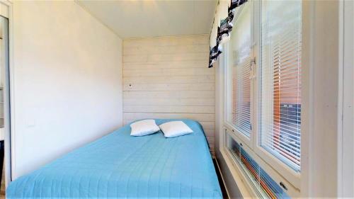 塞伊奈约基Pirjola的一间设有蓝色床和窗户的小卧室
