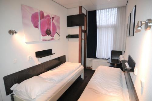鹿特丹比弗维纽酒店的客房设有两张床和窗户。