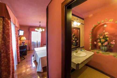 伊科德洛斯维诺斯圣马科斯标志酒店的一间带水槽的浴室和一张位于客房内的床