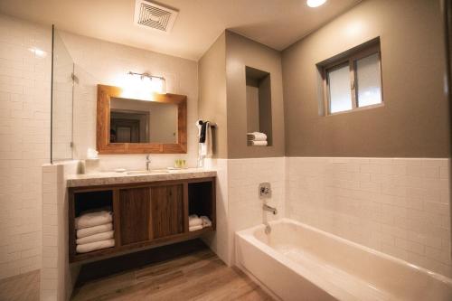 斯普林代尔Driftwood Lodge的一间带水槽、浴缸和镜子的浴室