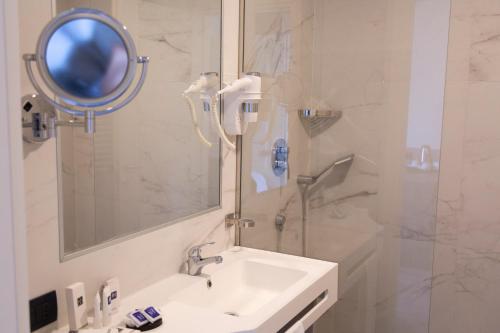 塞斯托-圣乔凡尼iH Hotels Milano St. John的一间带水槽、镜子和淋浴的浴室