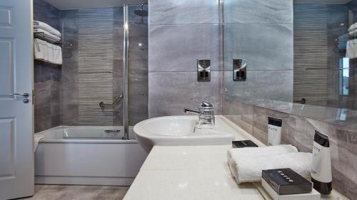 沃特福德塔酒店及休闲中心的浴室配有盥洗盆、卫生间和浴缸。