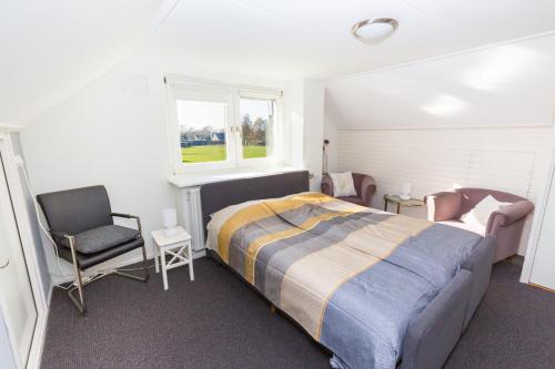 奥尔登扎尔Bed & Breakfast Kroese的卧室配有床、椅子和窗户。